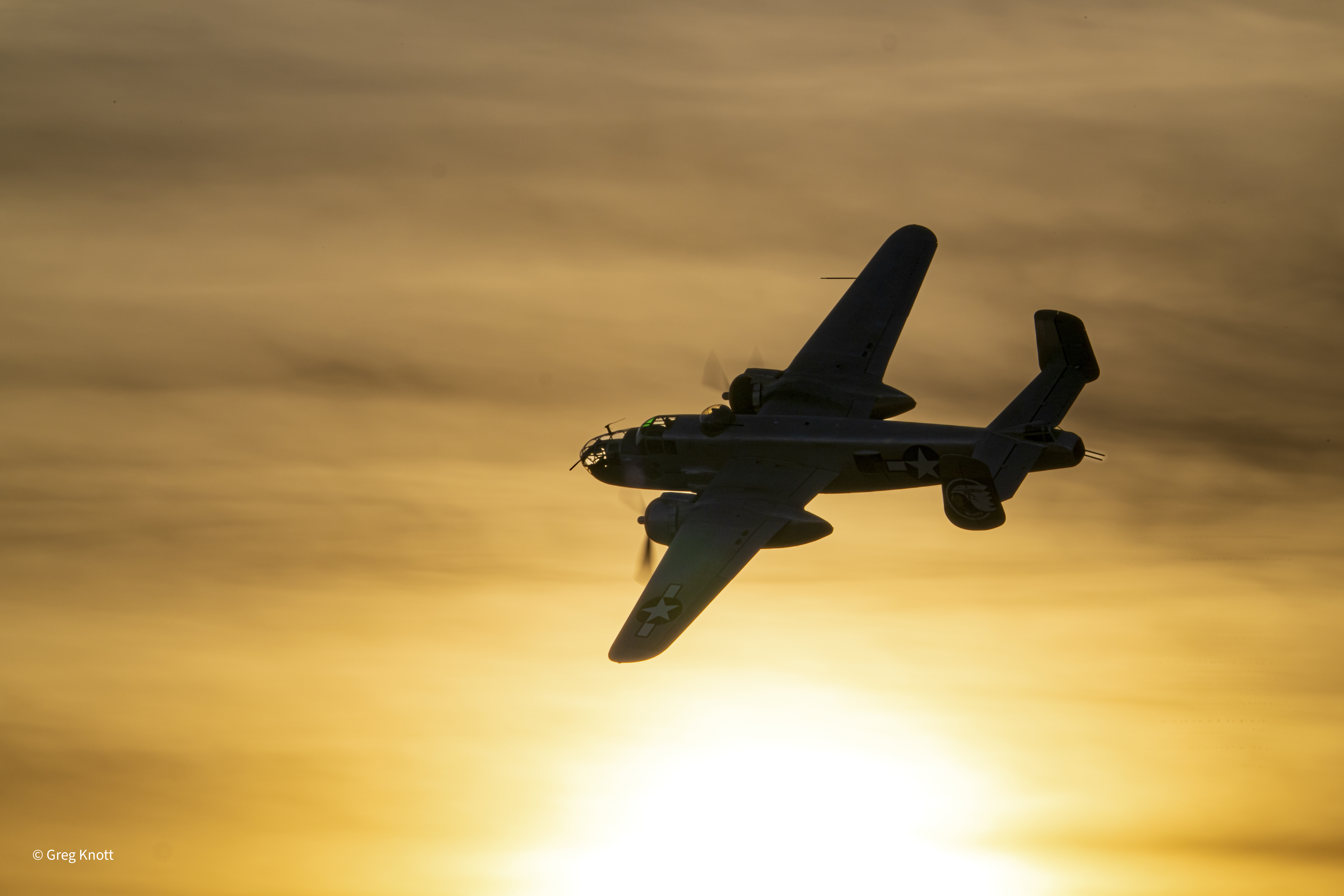 B25 airplane flying over the Arizona desert at sunset